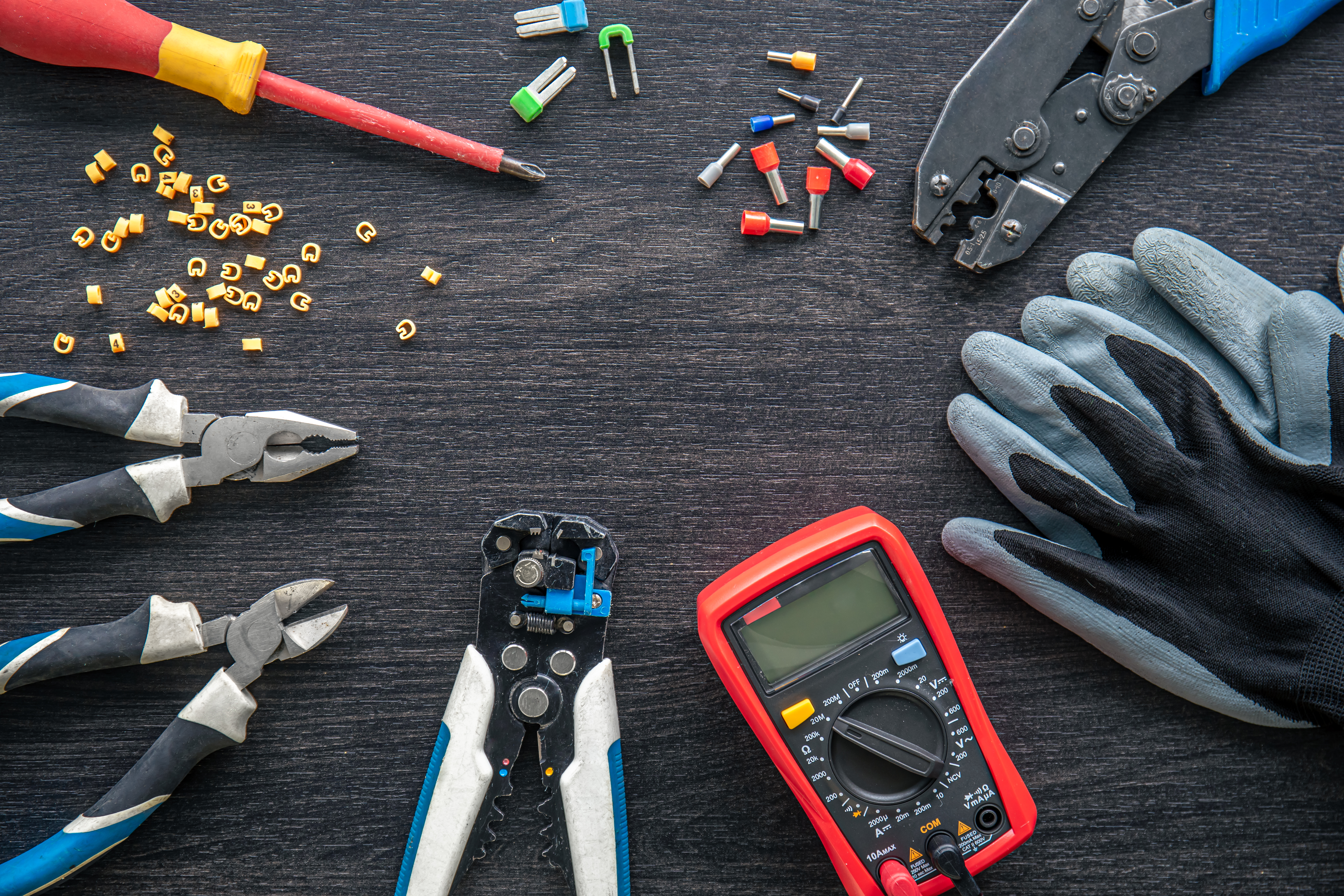 Electrical tools, gloves and materials on a workbench